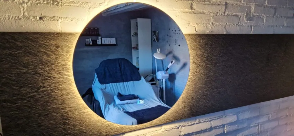 Verlichte spiegel met uitzicht op de behandelruimte